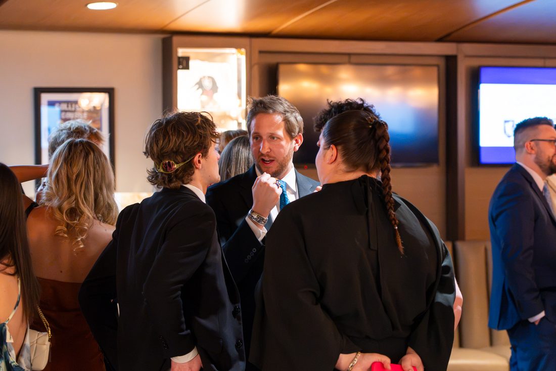 Guests mingling in formal attire at Blue Tie Gala